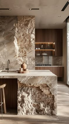 a modern kitchen with marble counter tops and wooden cabinetry, along with an island in the middle