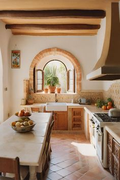 a large kitchen with an arched window and white counter tops, surrounded by tile flooring