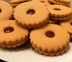 some cookies with jelly on them sitting on a plate