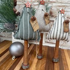 three small wooden christmas trees with tags on them