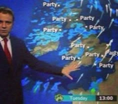 a man in a suit and tie standing next to a tv screen with weather maps on it