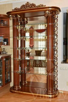 an ornate display case with glass doors in the middle of a wooden floored room