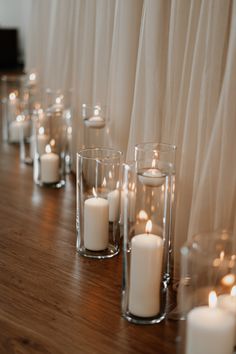 white candles are lined up on the table