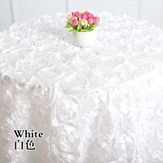 a white table cloth with flowers in a vase on it and the words white 11 16