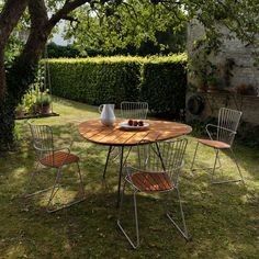 an outdoor table and chairs in the grass