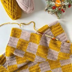 crocheted yellow and white blanket next to yarn