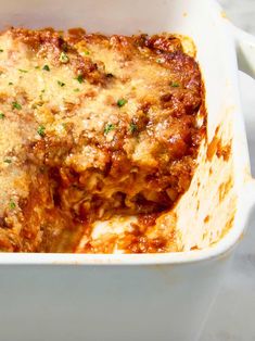 lasagna casserole with meat and cheese in a white dish on a table