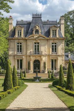 a large house with lots of trees and bushes around it's front entrance area