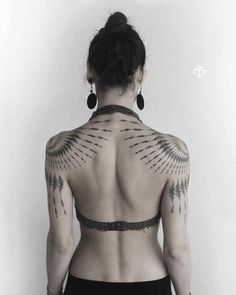 the back of a woman's body with tattoos on her upper and lower back