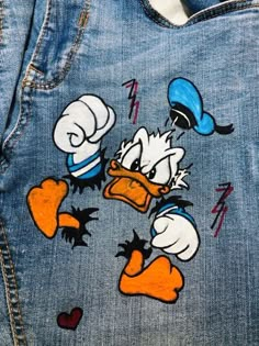 a pair of donald and daisy ducky painted on jean pants with the back pocket open