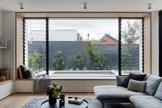 a living room filled with furniture and large windows