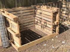 two wooden crates sitting next to each other on the ground in front of a fence