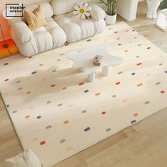 a living room with white furniture and colorful polka dot rug