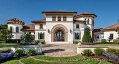 a large white house with lots of windows and landscaping