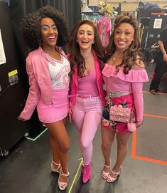 three women in pink outfits standing next to each other