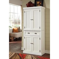 a tall white cabinet with two doors on the front and one door open to reveal a living room