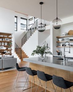 an open concept kitchen and living room with stairs leading up to the second floor area