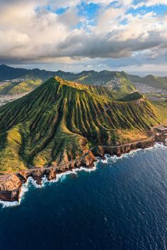 an aerial view of the coastline and mountains in hawaii, with blue water on both sides