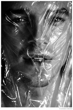 black and white photograph of a man wrapped in plastic