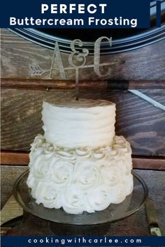 a white frosted cake sitting on top of a glass plate with the words perfect buttercream frosting