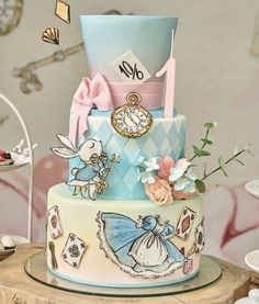 a multi layer cake decorated with an alice in wonderland theme