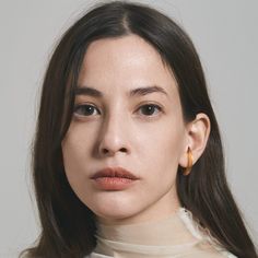 a close up of a person with long hair and wearing a turtle neck sweater, looking at the camera