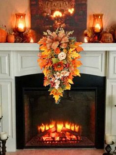 a fireplace decorated with fall flowers and candles