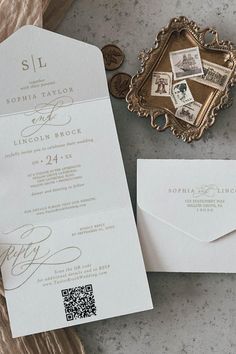 the wedding stationery is laid out next to an envelope with stamps on it and a gold frame