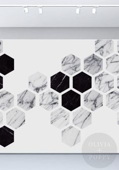 a white wall with black and white hexagons on it, in the middle of a room