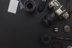 a camera and some other items on a black surface with a white card next to it