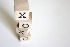 wooden blocks spelling the word xo and o on top of each other with letters that spell out