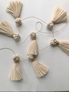 four tassels are arranged in the shape of an eight - pointed knot on a white surface