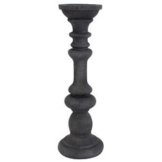 a tall black candle holder sitting on top of a table