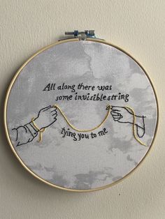 embroidery art with two hands holding each other's strings and saying, all along there was some invisible string flying you to me