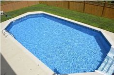 an above ground swimming pool in a backyard with grass and fence around the back yard