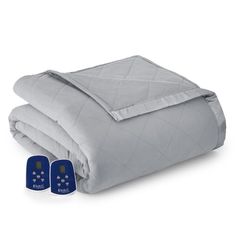 a blue comforter with two pillows on it and an electric thermometer next to it