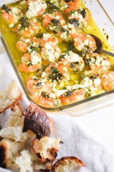 a casserole dish filled with shrimp and vegetables next to garlic bread crumbs