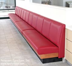 a red leather bench sitting in front of a counter