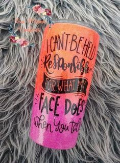 an orange and pink tumbler sitting on top of a fur covered floor next to flowers