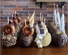 chocolate covered donuts are lined up in front of each other on a wooden table