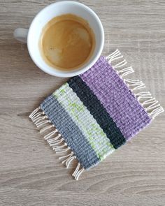 a cup of coffee sitting on top of a wooden table next to a colorful rug