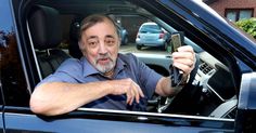 an older man sitting in the drivers seat of a car