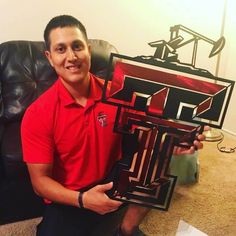 a man sitting on a couch holding up a trophy