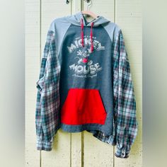 a blue and red hoodie hanging on a white door with the words mickey mouse printed on it