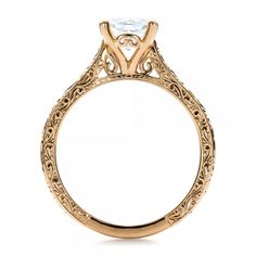 a gold engagement ring with an oval cut diamond in the center and filigrees