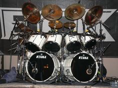 a set of drums sitting on top of a stage in front of a sign that says tama