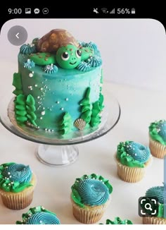 there are cupcakes with green frosting and blue icing on the cake