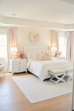 a white bed sitting in a bedroom on top of a hard wood floor