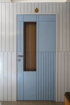 a blue door with blinds on it in a white wall next to a counter top