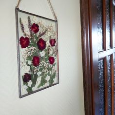 a painting hanging on the wall next to a wooden door with flowers painted on it